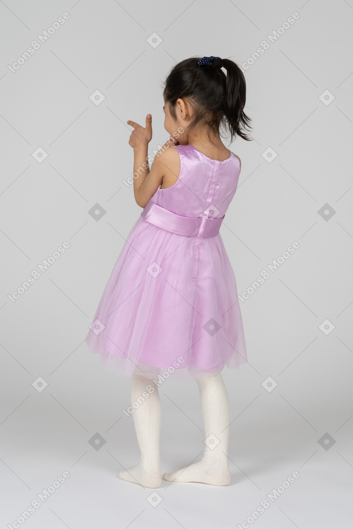 Garota de vestido rosa apontando com uma arma de dedo
