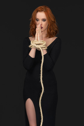 A frontal view of the sexy praying woman with hands tied