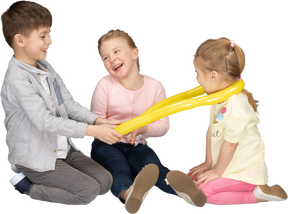 Niños divirtiéndose jugando con globo amarillo