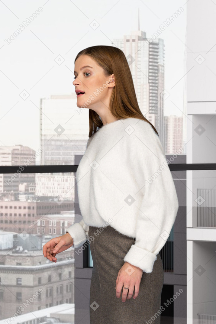 Une femme debout devant une fenêtre
