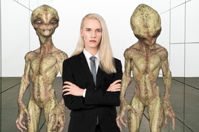Person in suit standing next to aliens