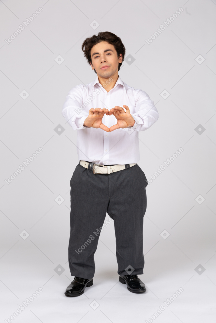 Молодой человек показывает знак сердца руками