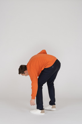 Junger mann im orange sweatshirt springen