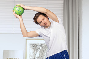 A man holding a green ball above his head