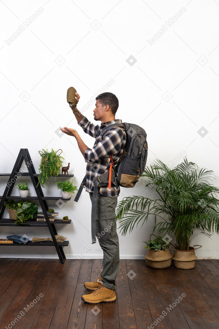 Side view of a backpacker holding up an empty flask