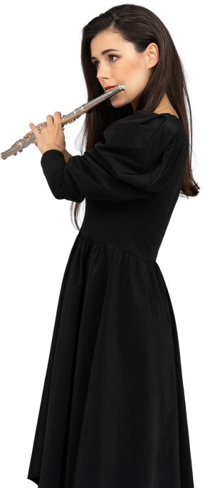 Вид в три четверти серьезной молодой леди в черном платье, играющей на флейте