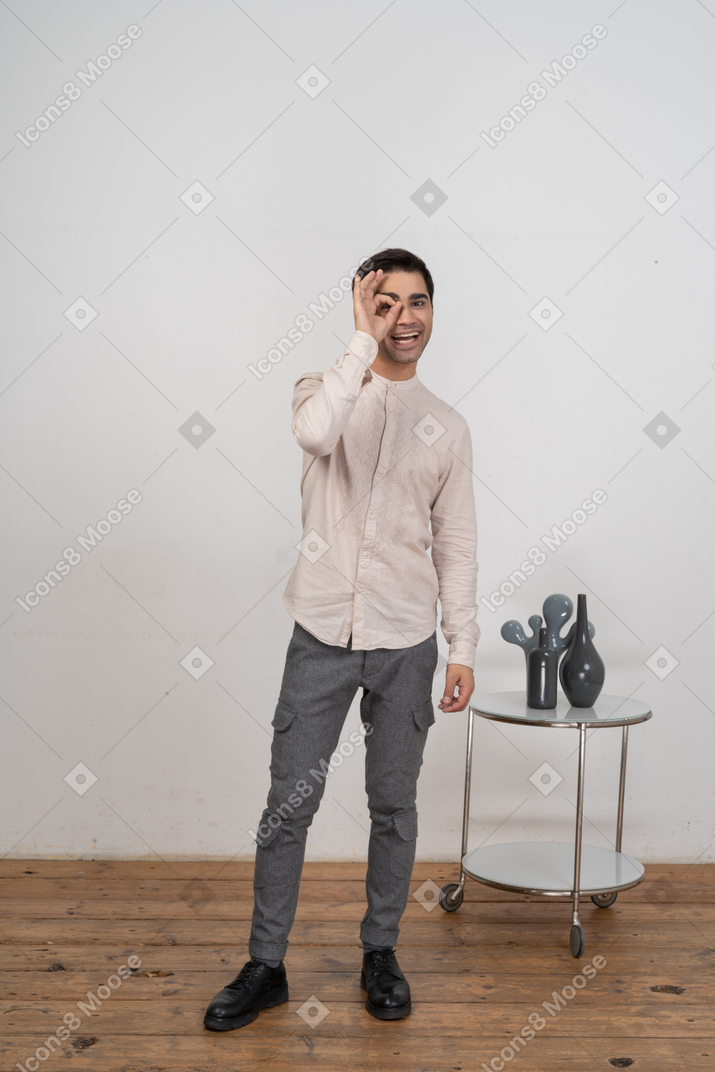 Vue de face d'un homme en vêtements décontractés regardant à travers les doigts