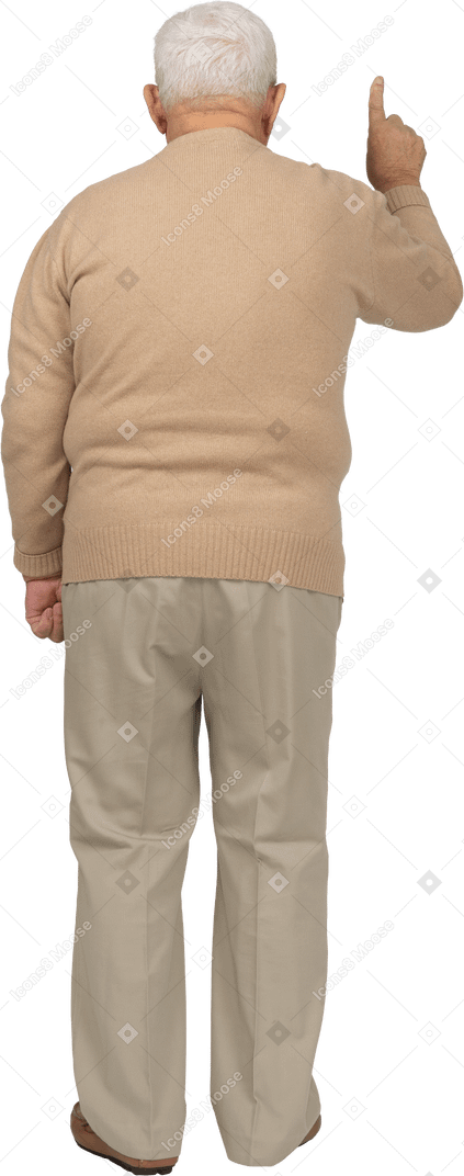 Vista trasera de un anciano con ropa informal apuntando hacia arriba con el dedo
