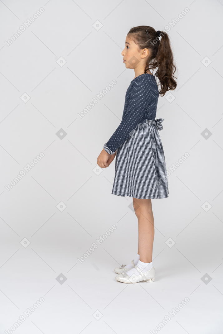 Side view of a girl looking surprised with hands clasped in front of her