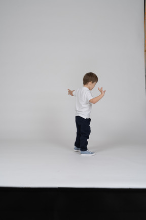 Back view of a boy raising his arms