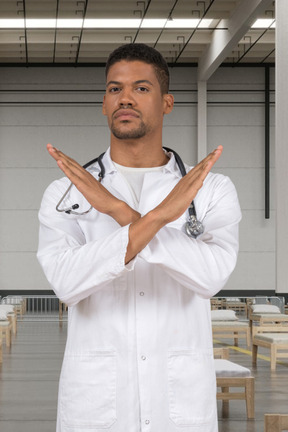 A man in a white lab coat standing with his hands crossed