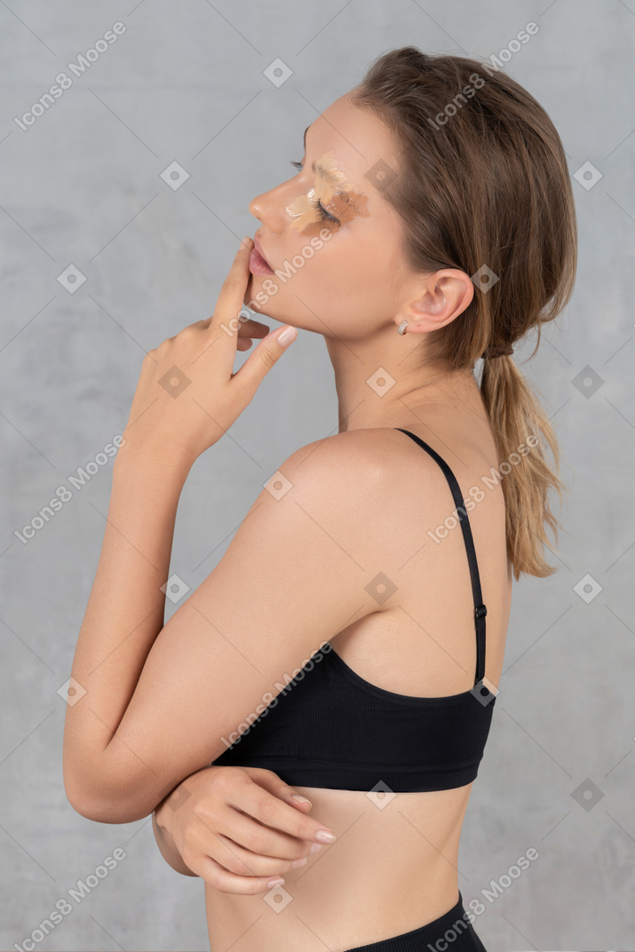 Vue latérale d'une jeune femme avec différentes nuances de fond de teint sur son visage