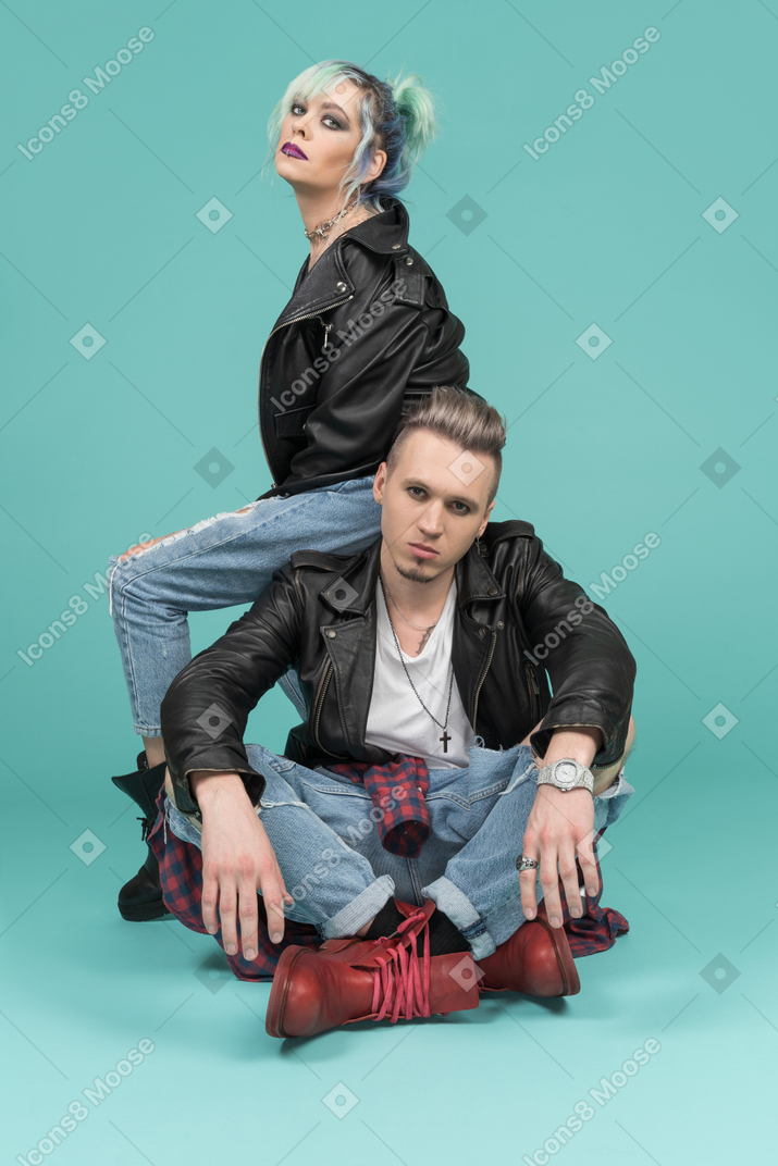 Turquoise haired punk woman sitting on her boyfriend`s back
