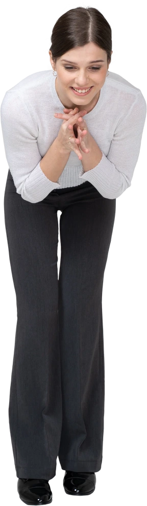 Front view of a happy woman in suit bending down