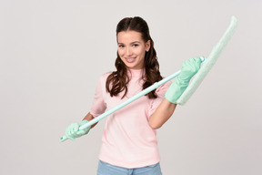 Attractive young woman holding a mop