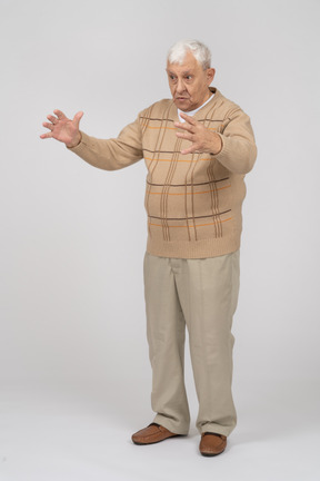 一位穿着休闲服的老人的正面图，显示某物的大小