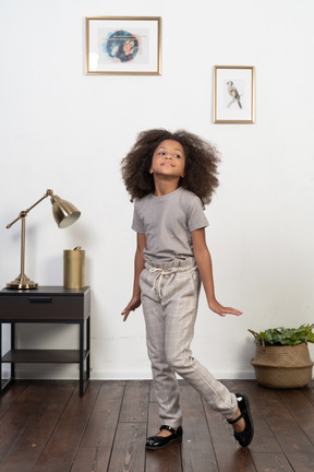 Good looking girl kid posing on the apartment background