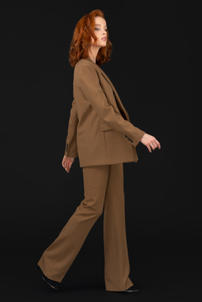 A woman in a brown suit is walking