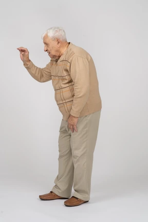 Side view of an old man in casual clothes showing size of something