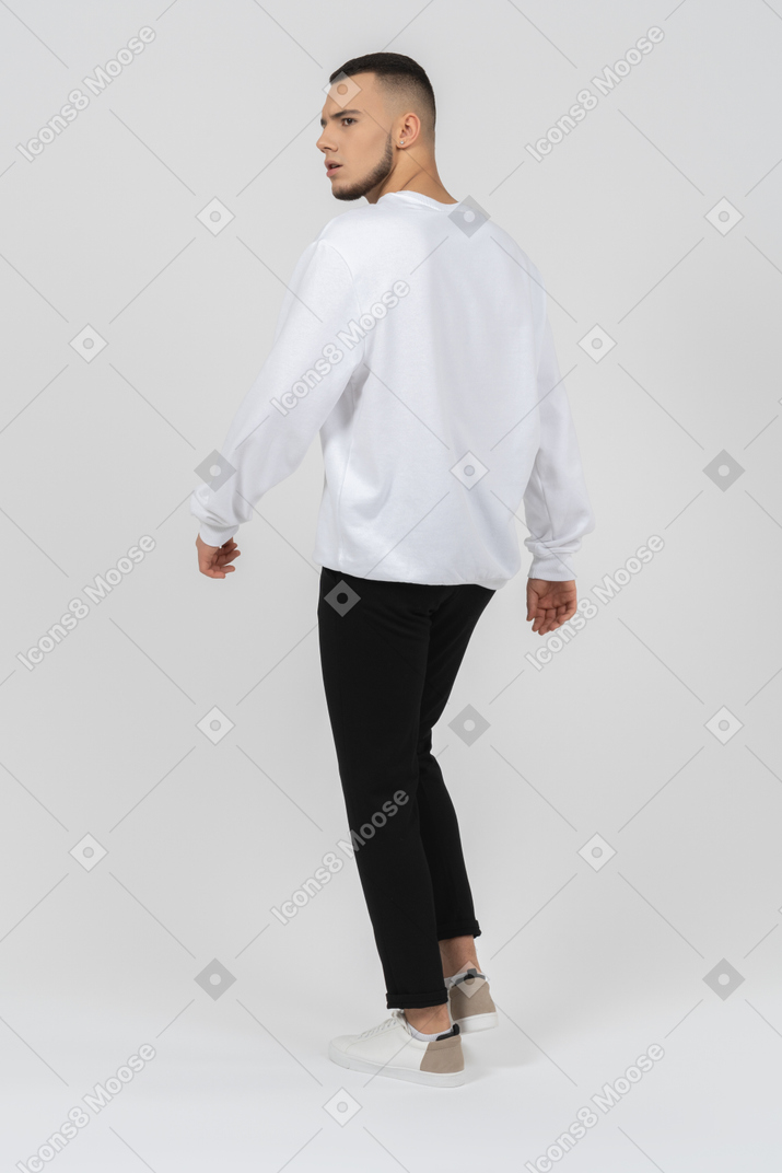Young man in casual clothes walking away