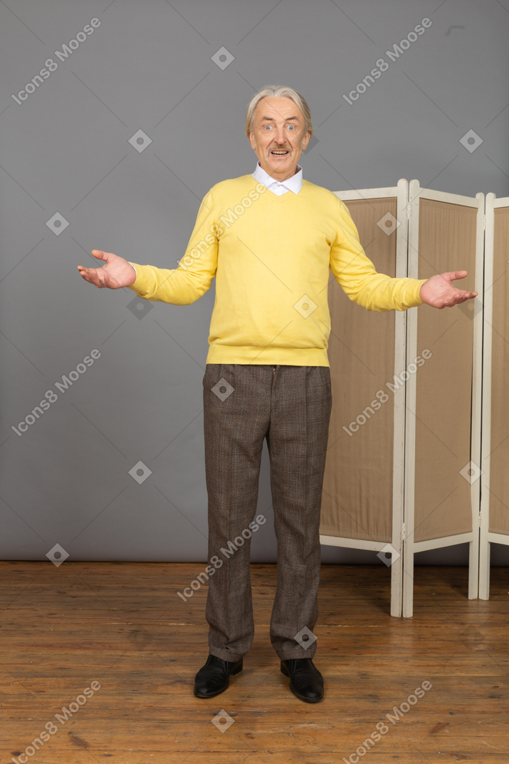 Vista frontale di un uomo anziano sorridente vicino allo schermo alzando le mani
