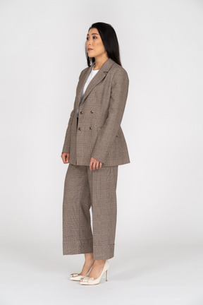 Three-quarter view of a young lady in brown business suit