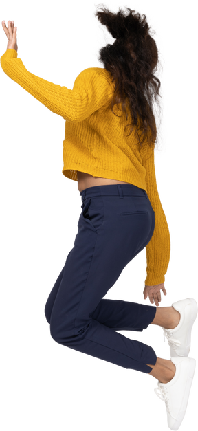 Side view of a girl in casual clothes jumping and touching her foot