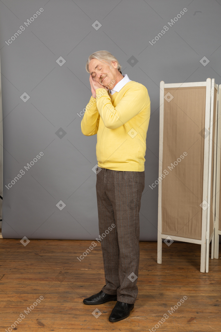 Side view of a sleeping old man putting hands under his cheek