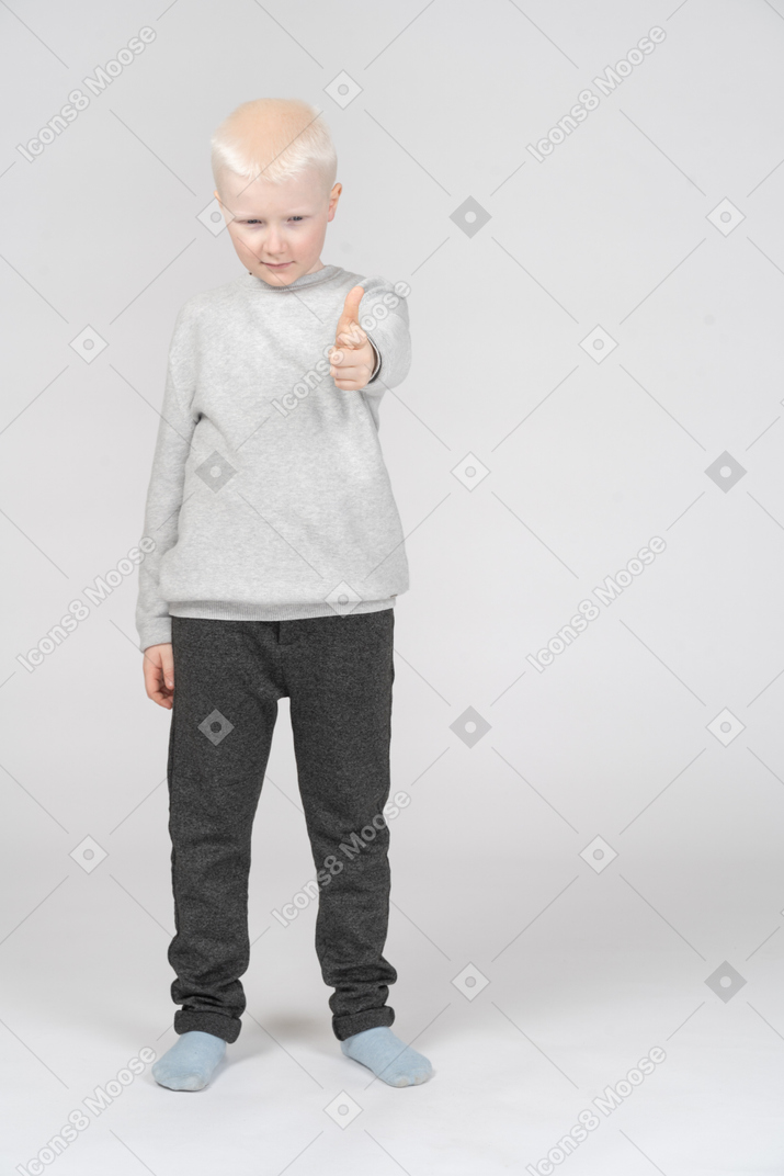 親指を立てるカジュアルな服装の少年