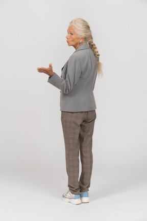 Rear view of an old woman in suit blowing a kiss