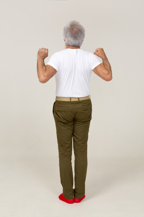 Back view of a man stretching his arms