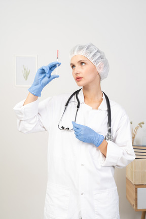 注射器を保持している若い女性医師の正面図
