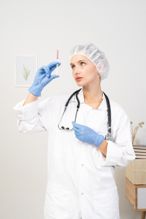 Front view of a young female doctor holding a syringe