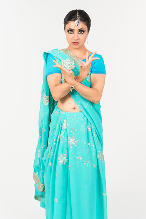 Young indian woman in blue sari standing in dance position