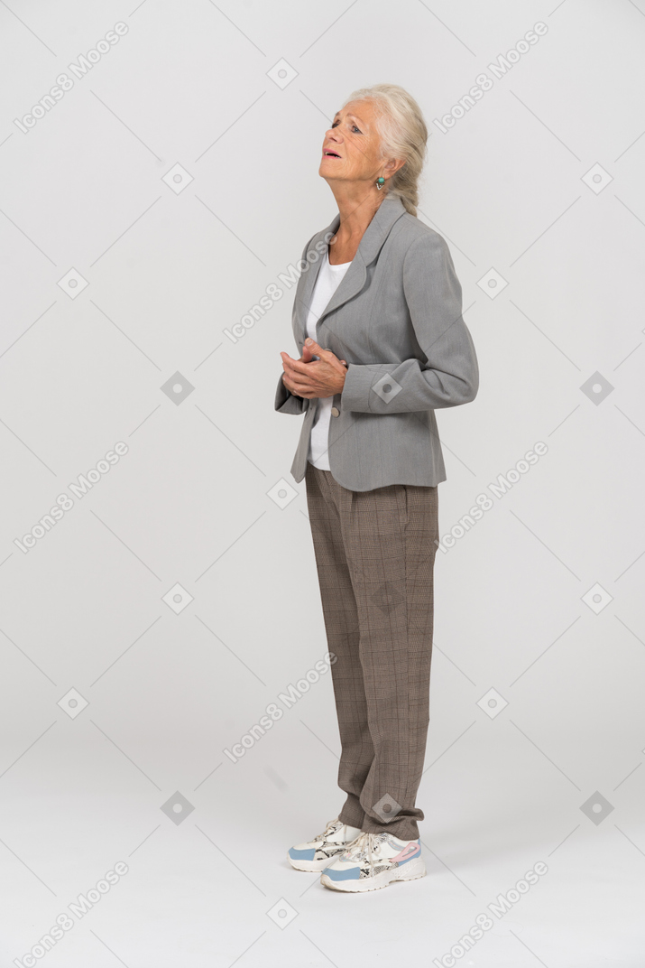 Traurige alte dame im anzug, die im profil steht