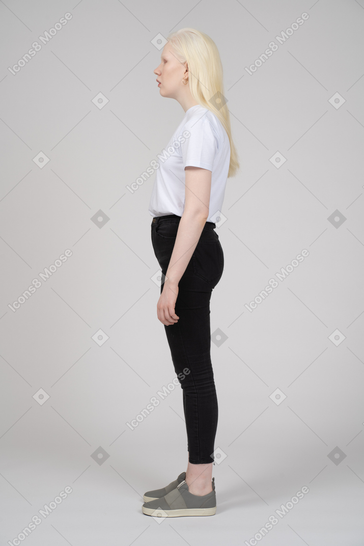 Side view of a standing young lady in casual clothes