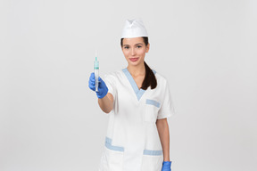 Enfermeira atraente demonstrando uma seringa descartável