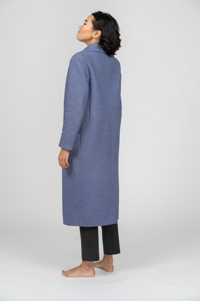 Vista posteriore di una donna in cappotto blu in piedi
