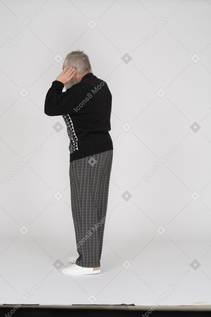 Rear view of old man pulling ears