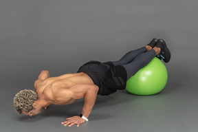 Homme faisant des pompes sur un ballon de fitness