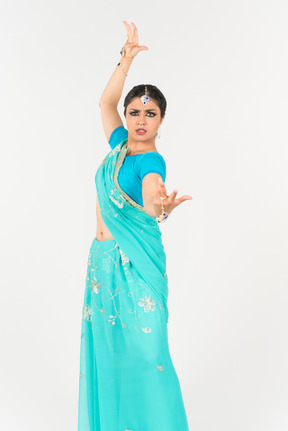 Jeune femme indienne en sari bleu debout en position de danse