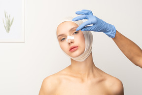 Female patient with gloved hand next to her face