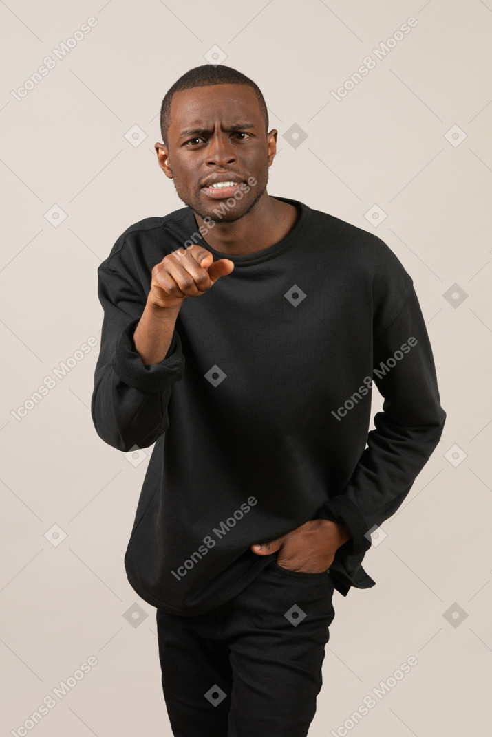 Confused young man pointing at camera