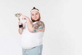 Big guy in sportswear holding a trophy