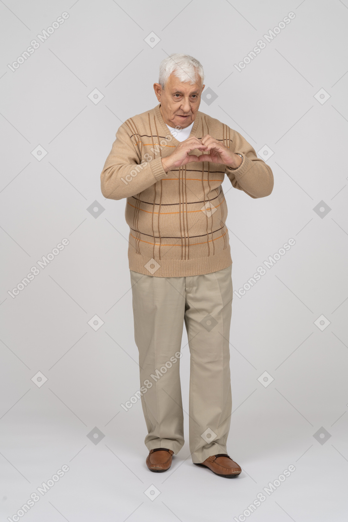 손가락으로 하트를 만드는 평상복을 입은 노인의 전면 모습