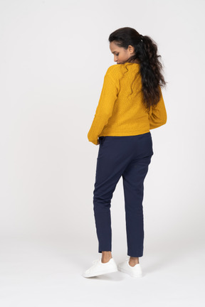 Rear view of a girl in casual clothes looking down