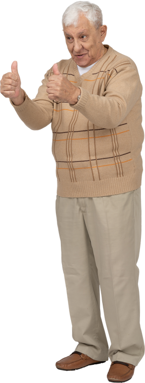Vista frontal de um velho feliz em roupas casuais, mostrando os polegares