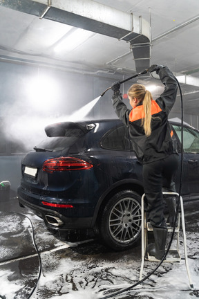 Young woman washing car