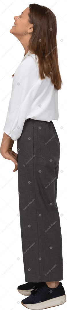 Side view of a smiling young lady in office clothing throwing head back