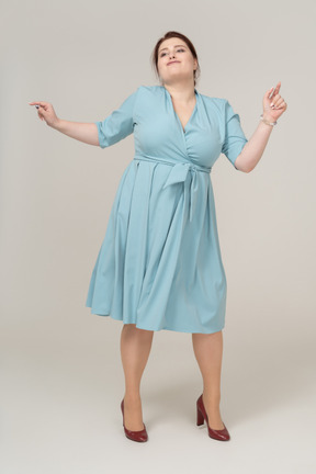 Vue de face d'une femme en robe bleue dansant